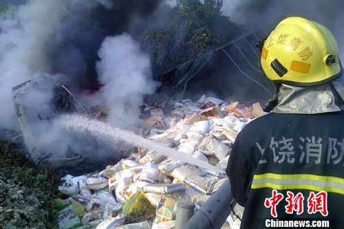 8月1日6时左右，沪昆高速上饶段一货车侧翻着火，驾驶室烧成空壳。图为现场一片狼藉，货物散落一地。吴兵章 摄